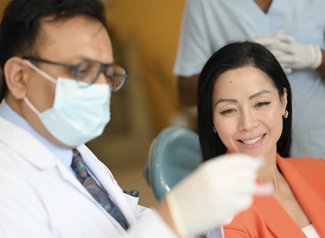 Dr. Ameet S. Dixit showing a patient her treatment at Ark Dental Global